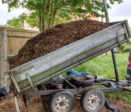 Trailer tipped up with a loose load of woodchip